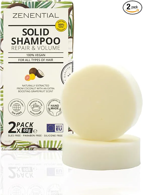 Mujer aplicándose champú sólido en la ducha, manos con espuma natural
